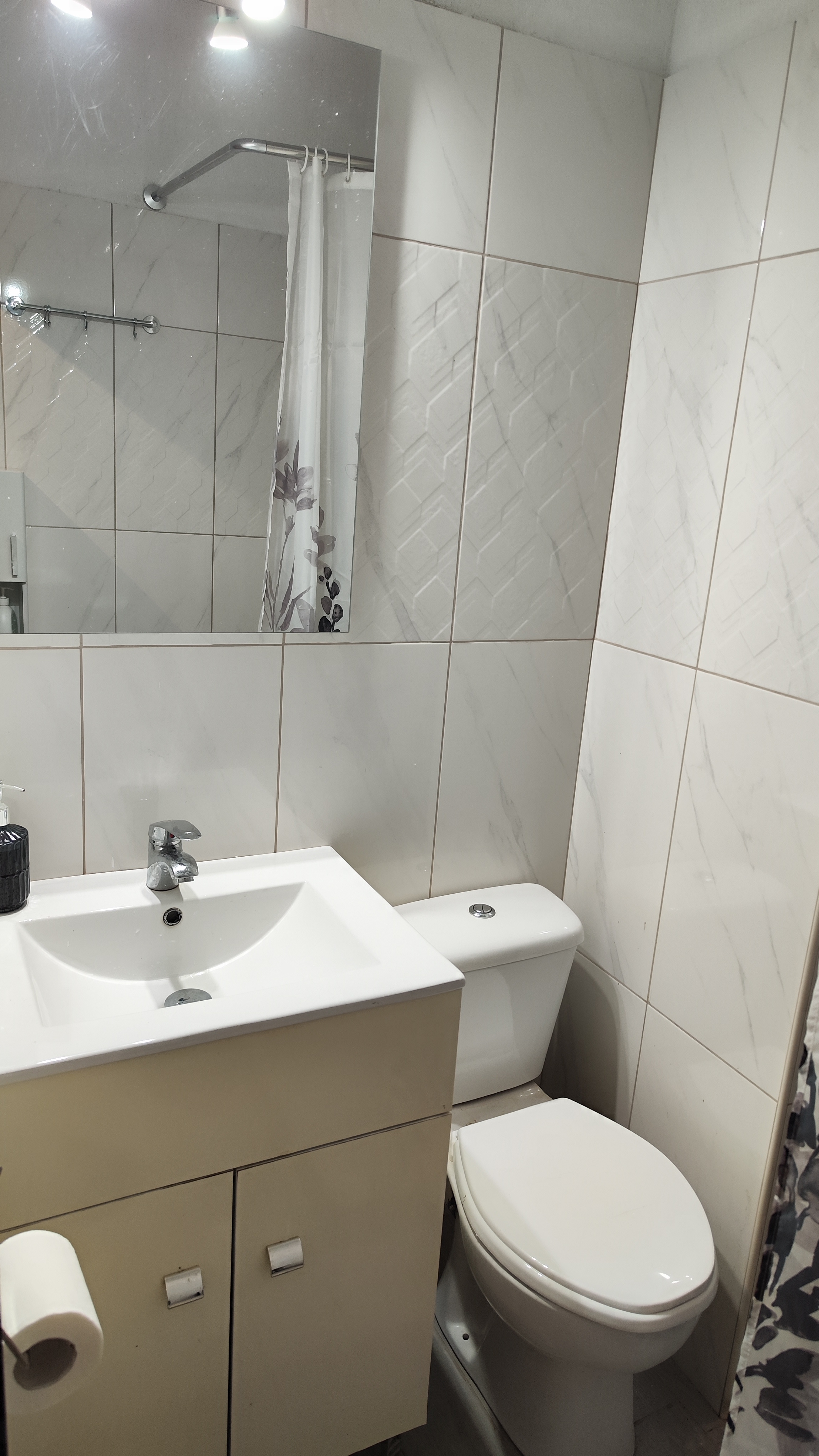 Clean bathroom with a walk-in shower, vanity unit and mermaid wall detail